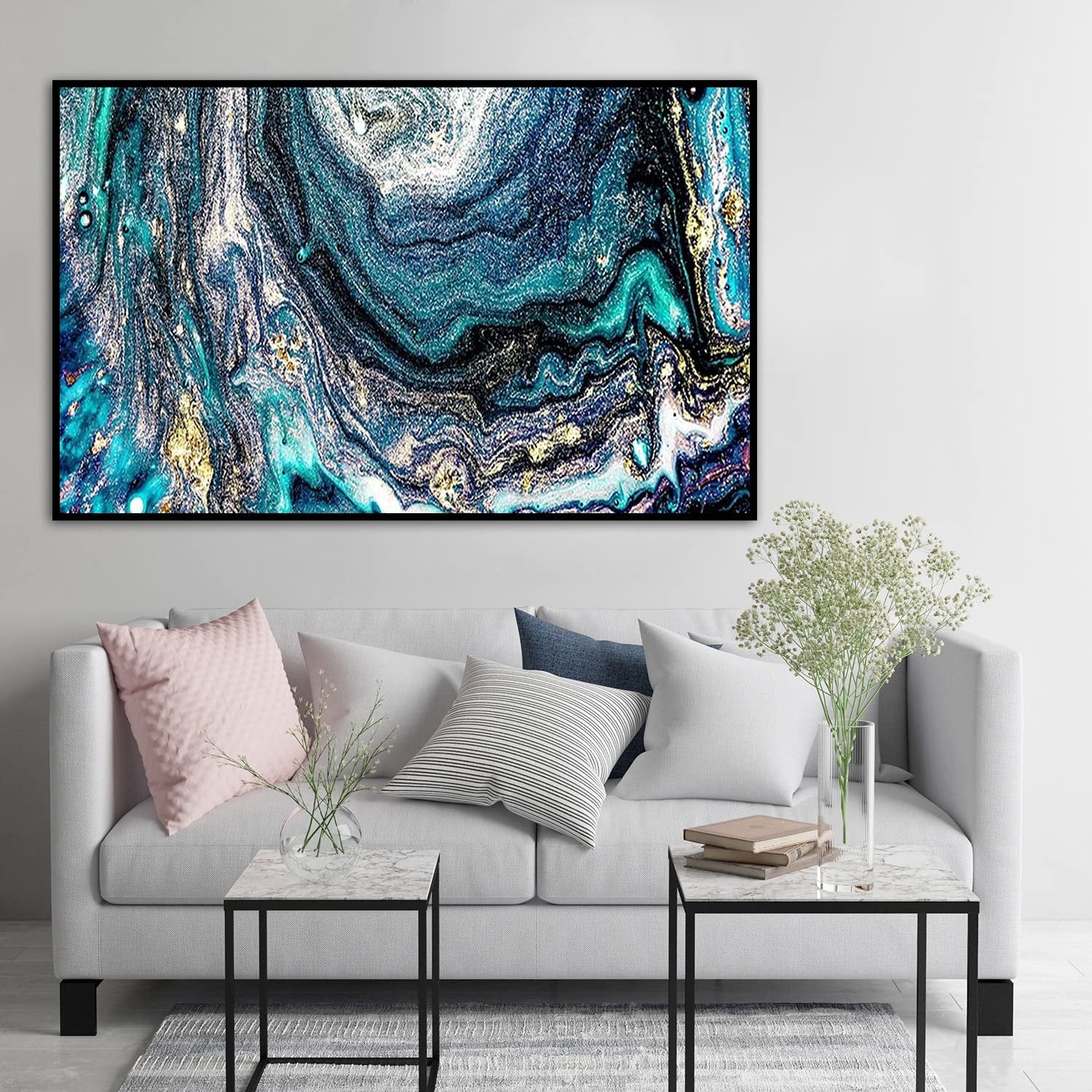 Abstract fluid art painting with teal, blue, black, and gold swirls, framed and hung above a sofa.