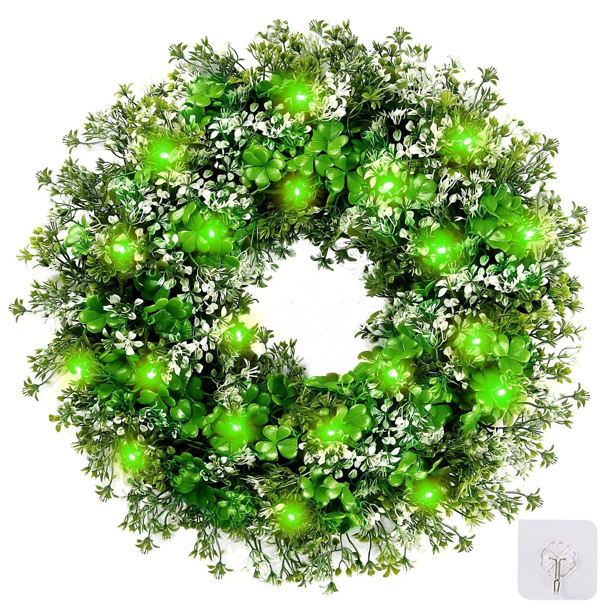 St. Patrick's Day shamrock wreath with green LED lights, plastic clover and flower accents, shown on a white background with a hook accessory.