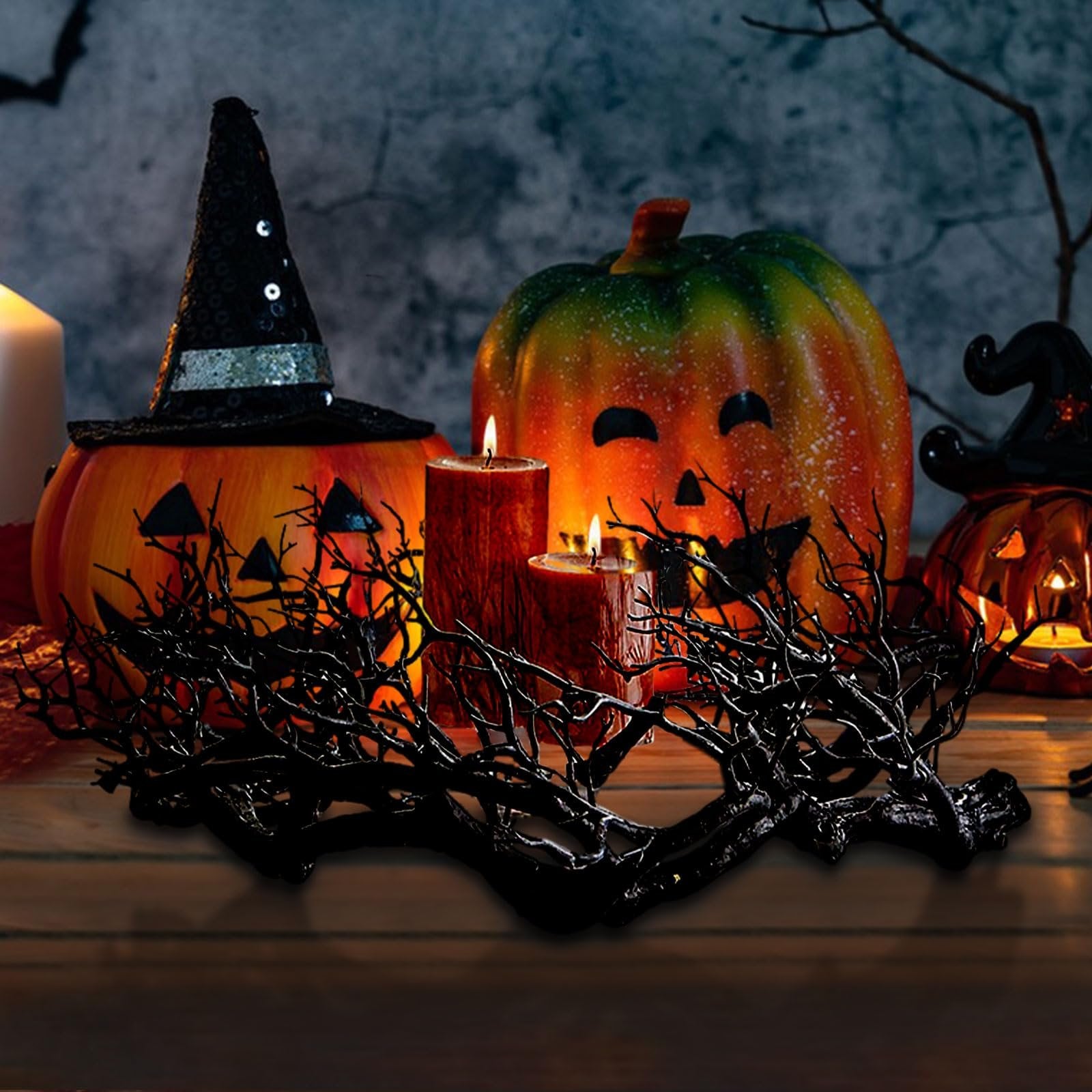 Halloween scene with jack-o'-lanterns, candles, and a black twig centerpiece on a wooden surface.