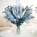 Dusty blue dried pampas grass bouquet with white grass, reeds, eucalyptus, bunny tail, and lavender in a green vase.