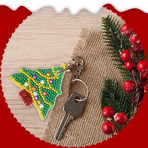 Diamond art Christmas tree keychain with keys on burlap and wood background with festive berries and pine sprigs