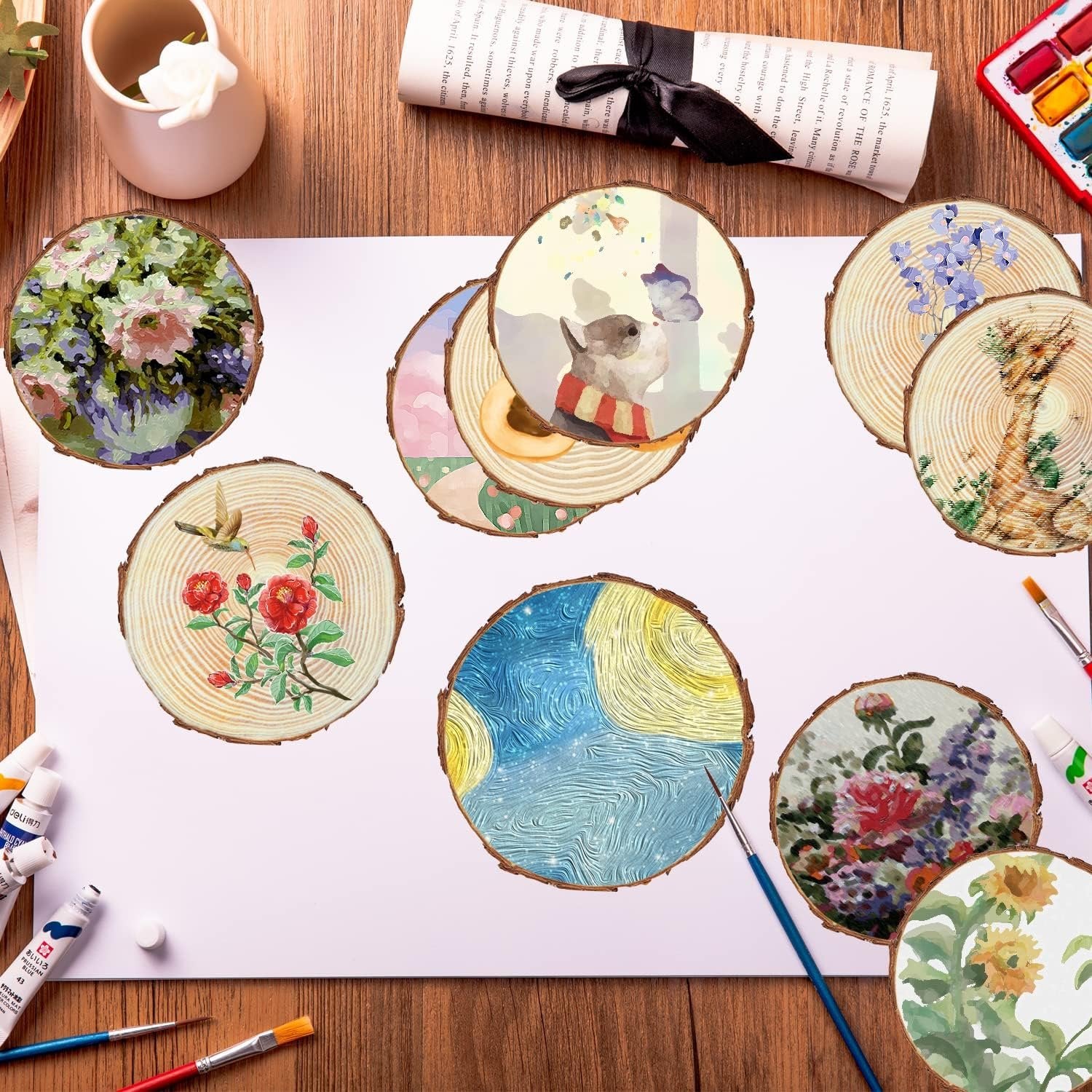 Assortment of unfinished wood slices with painted designs, arranged on white paper with art supplies.
