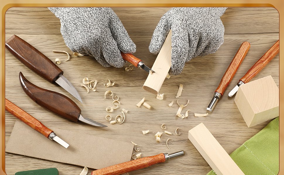 Hands wearing protective gloves carving wood with a knife, surrounded by wood shavings and carving tools.