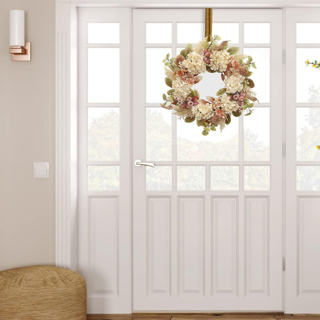 Fall wreath with hydrangeas and pampas grass hanging on a white door
