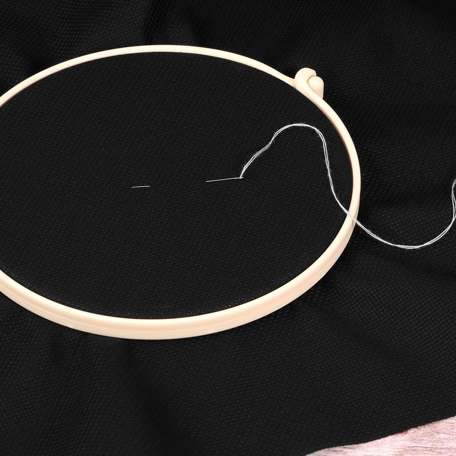 Black Aida cloth cross stitch fabric with embroidery hoop and needle