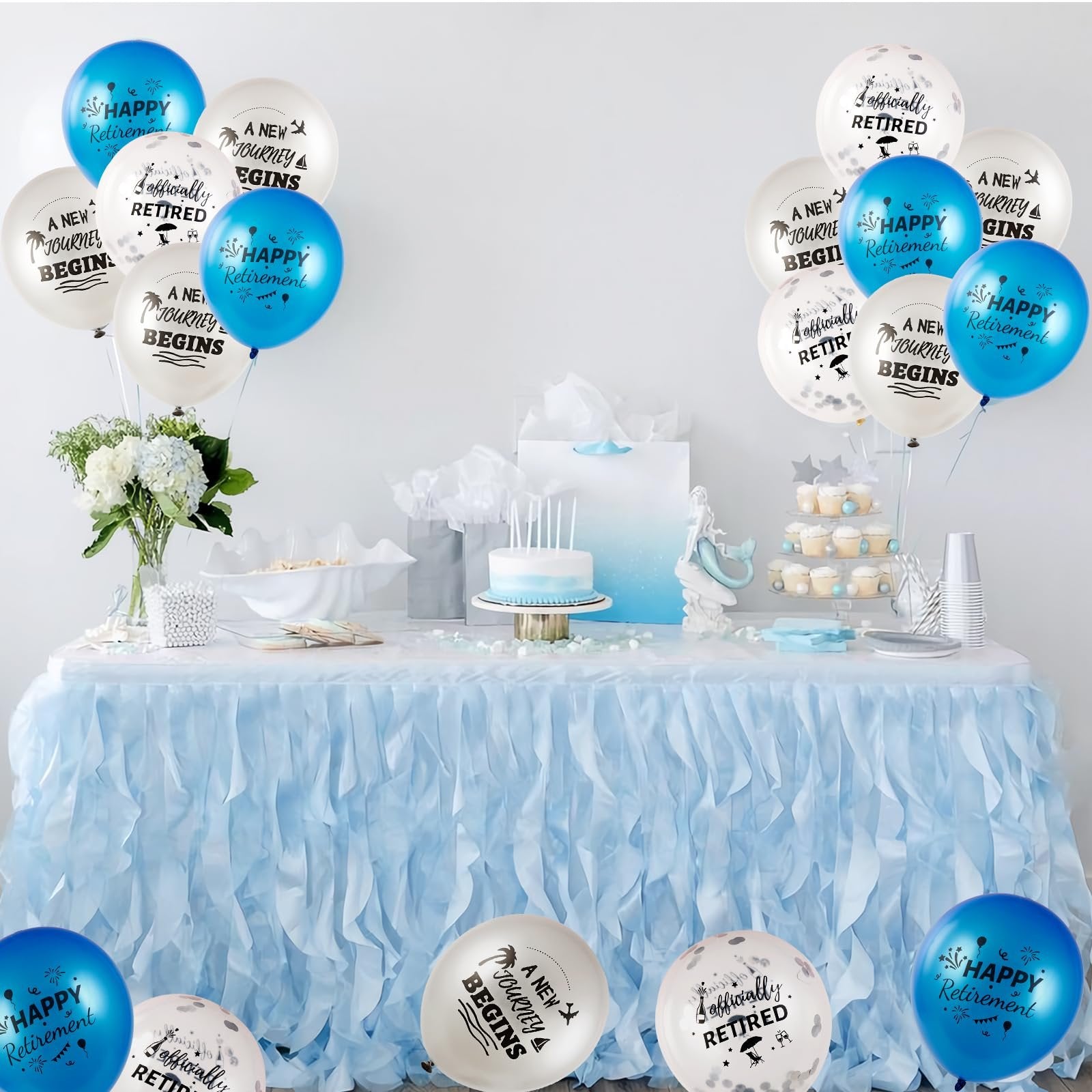 Retirement party table setting with blue and white balloons, cake, cupcakes, and flowers.