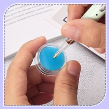 Close-up of hands holding a diamond painting light pen and a blue clay storage case.