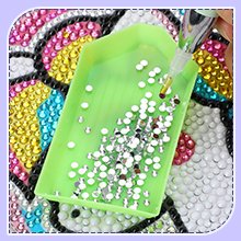 Diamond painting tray with rhinestones and a light pen applicator, close-up view.