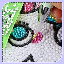 Diamond painting pen with diamond beads and a partially completed diamond art canvas