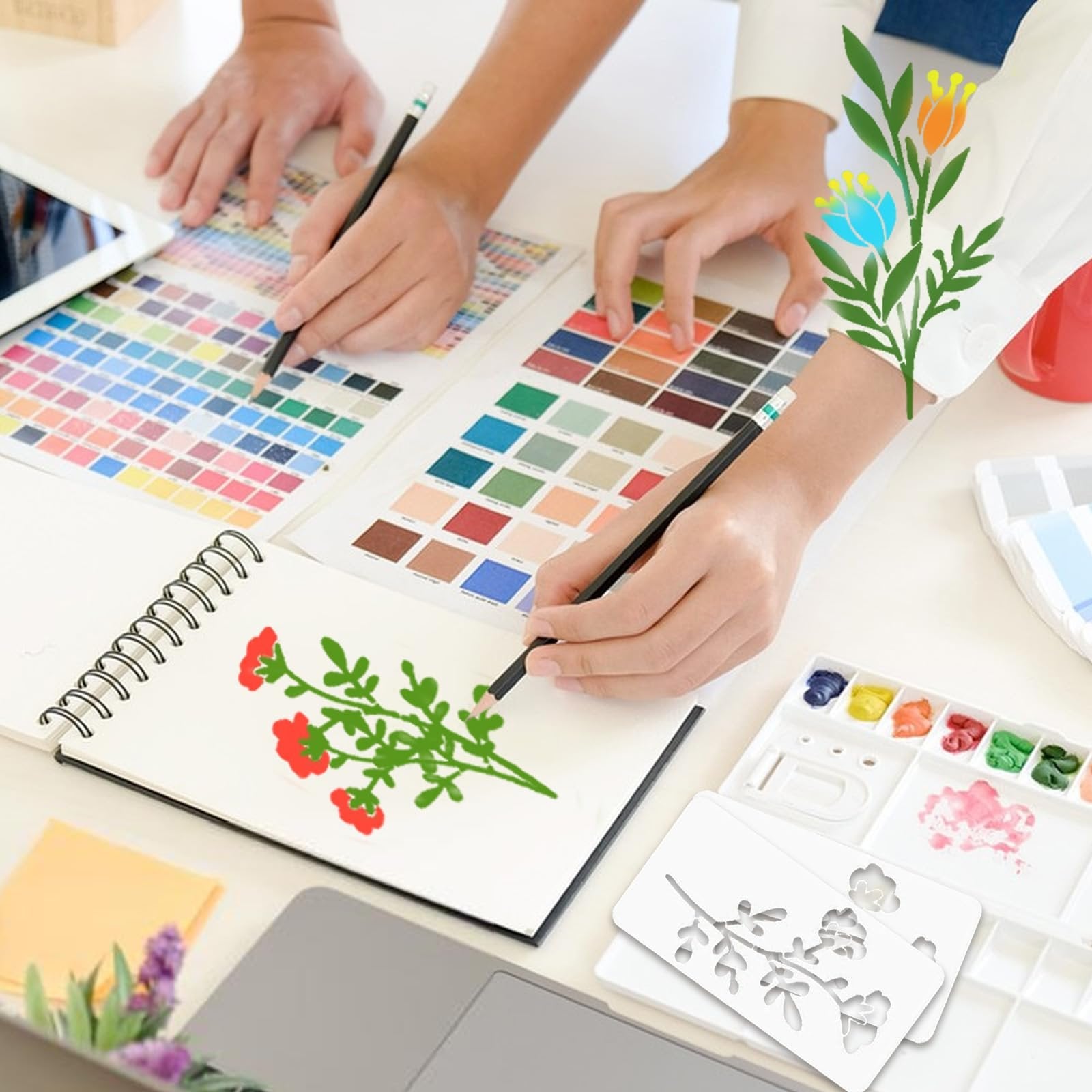 Hands sketching floral designs with color swatches and stencils on a desk