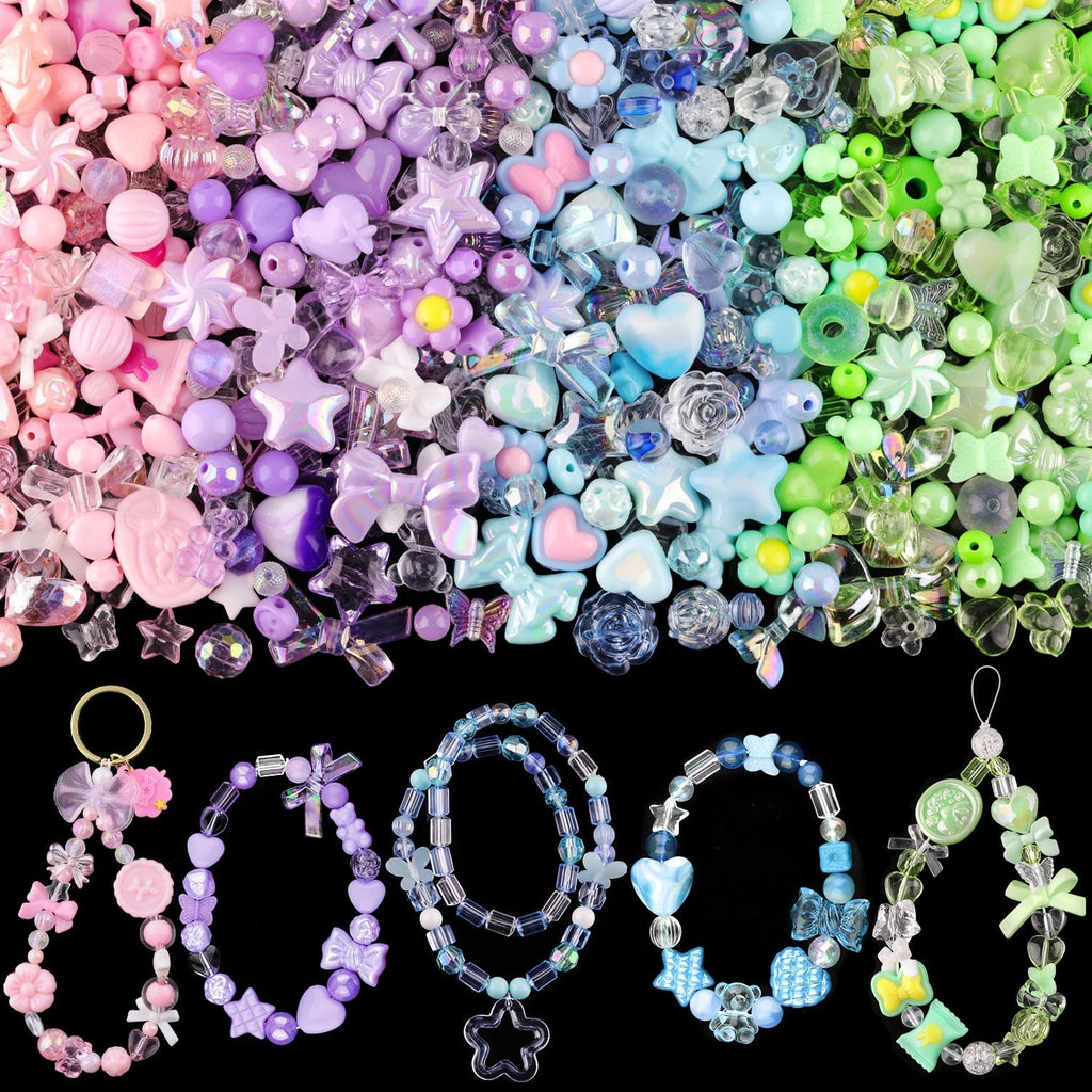 Assorted acrylic beads in pink, purple, blue, and green, with finished bracelets and charms on a black background.