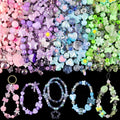Assorted acrylic beads in pink, purple, blue, and green, with finished bracelets and charms on a black background.