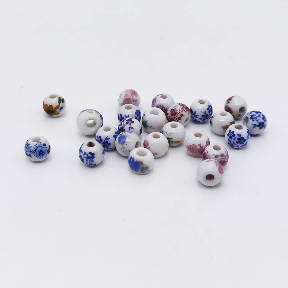 Assortment of 8mm round porcelain beads with floral patterns, scattered on a white background.