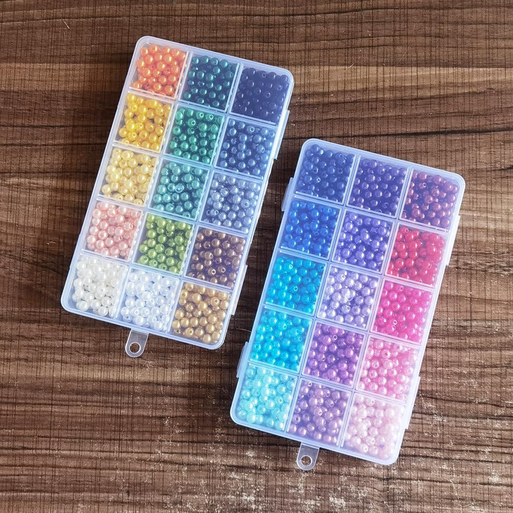 Two clear plastic storage boxes filled with colorful 6mm plastic pearl spacer beads, viewed from above on a wooden surface.