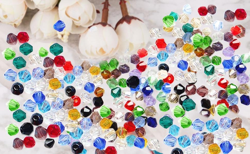 Scattered 4mm faceted crystal bicone beads in various colors including red, blue, green, and clear, with decorative white flowers in the background.