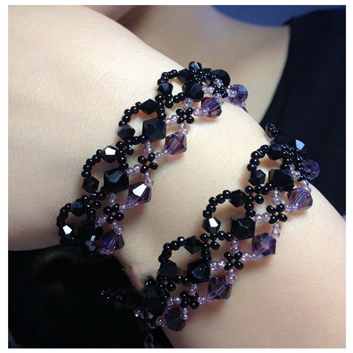 Two beaded bracelets with black and purple faceted beads worn on a person's arm.