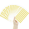 Hand holding fan of sheets with holographic gold star stickers