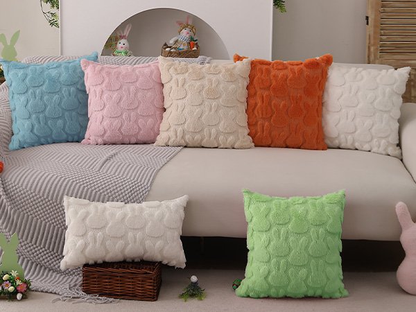 Various plush faux fur pillow covers with embossed bunny patterns arranged on a sofa and floor.