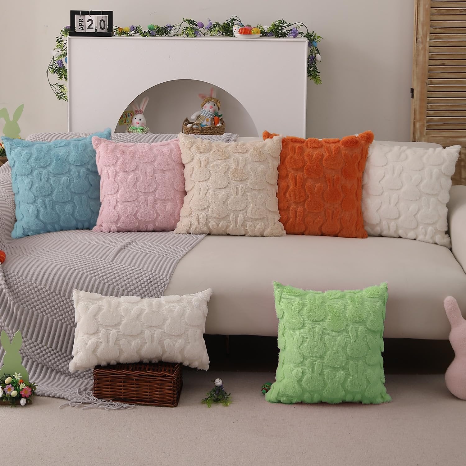 Easter themed throw pillow covers with bunny pattern in various colors arranged on a sofa and floor.