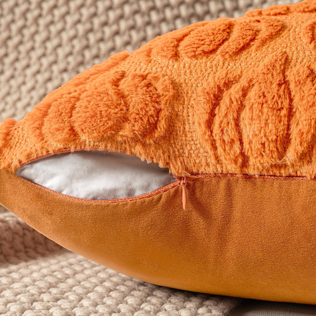 Close-up of an orange faux fur pumpkin pillow cover with a textured pattern and a visible zipper.