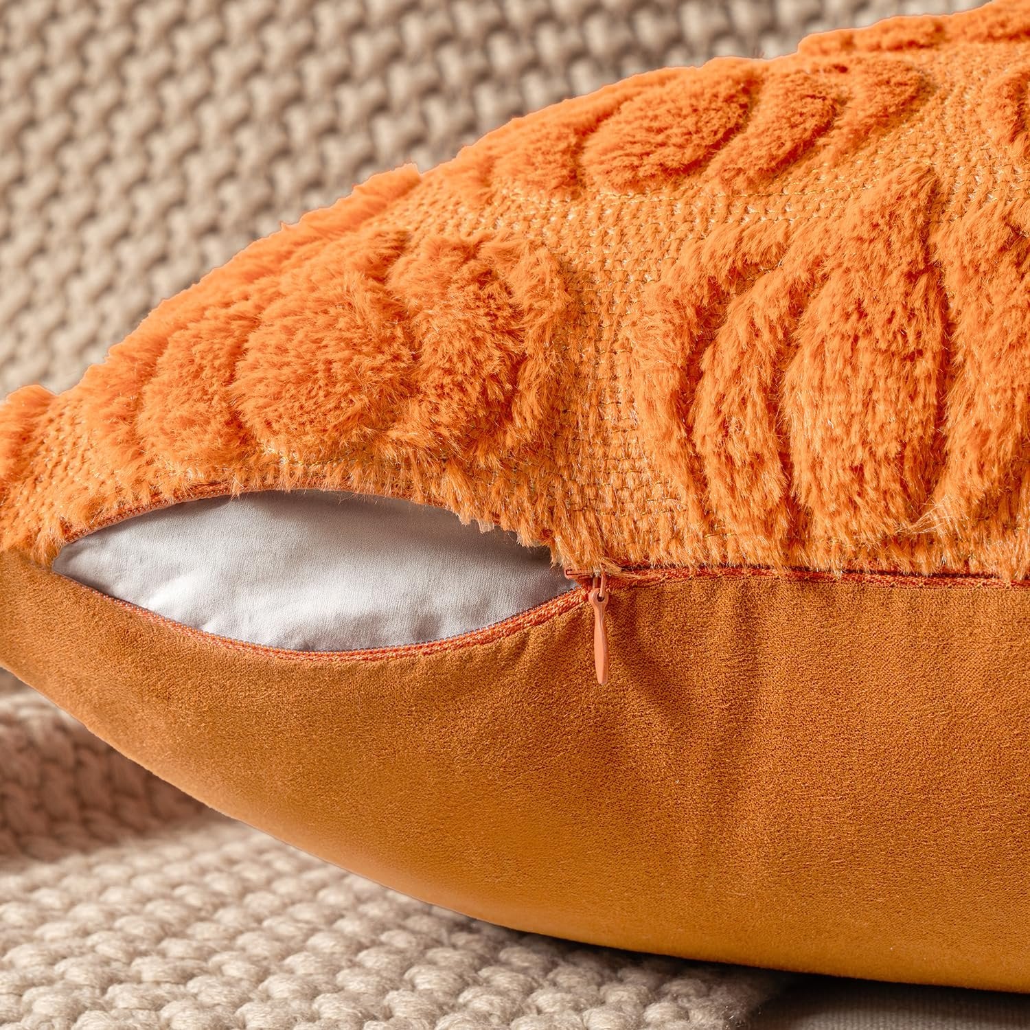 Close-up of an orange faux fur pumpkin pillow cover with a textured pattern and a visible zipper.