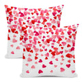 Two decorative pillow covers with a scattered pink and red heart pattern on a white background.
