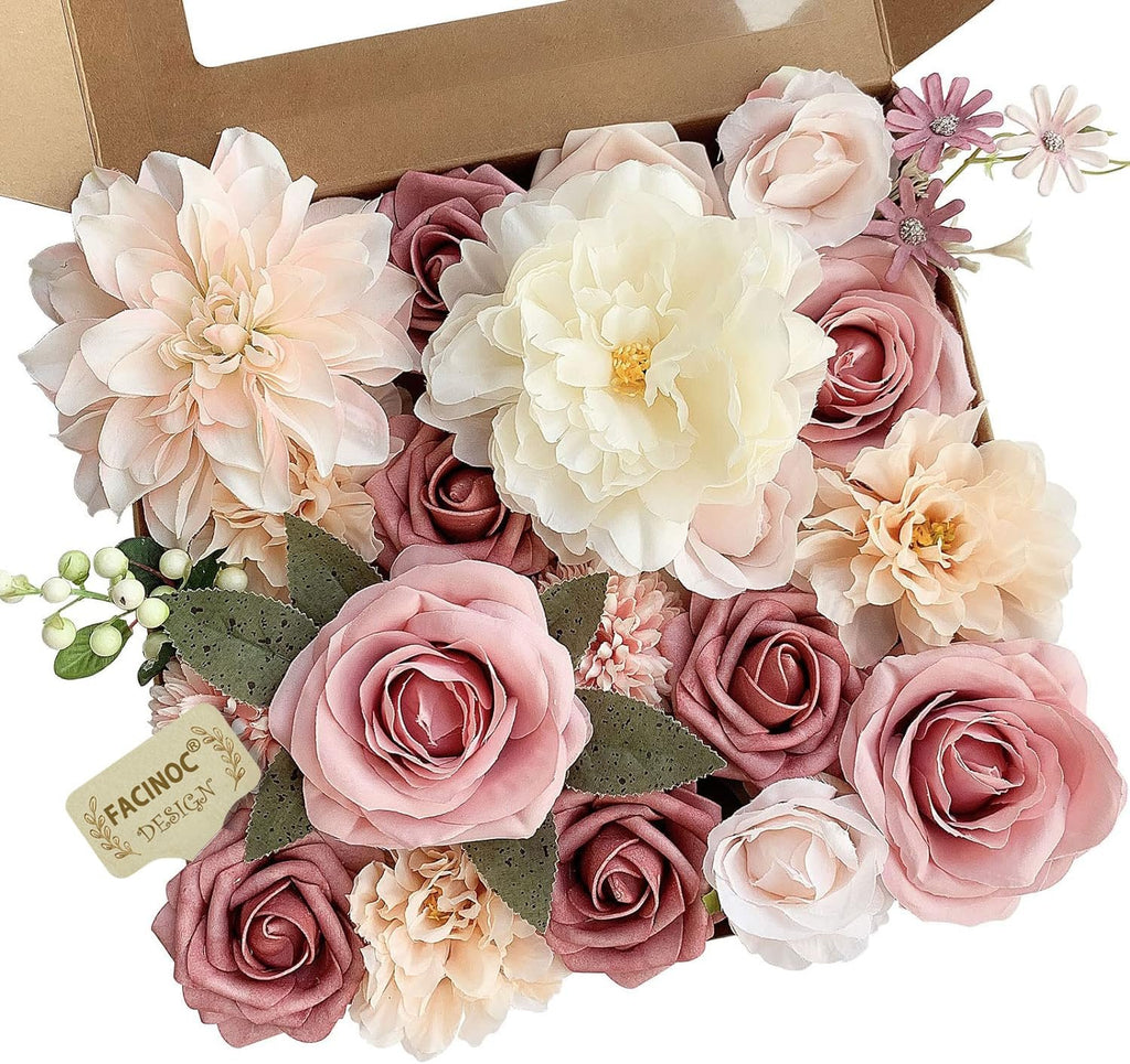 Dusty blush pink artificial rose bouquet set with various flowers and green leaves in a cardboard box.