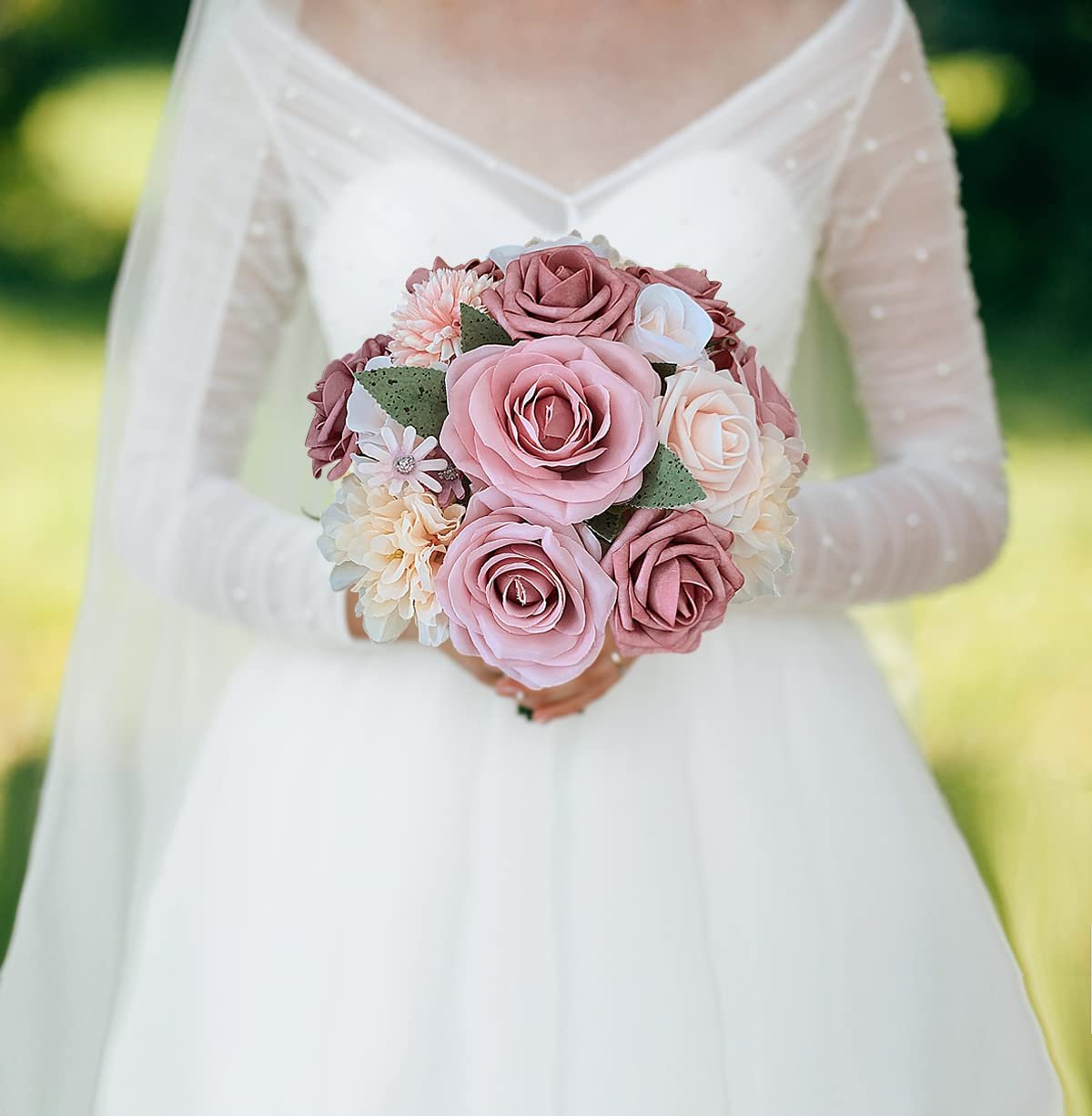 Bride holding a dusty blush pink artificial rose bouquet with a white wedding dress and veil