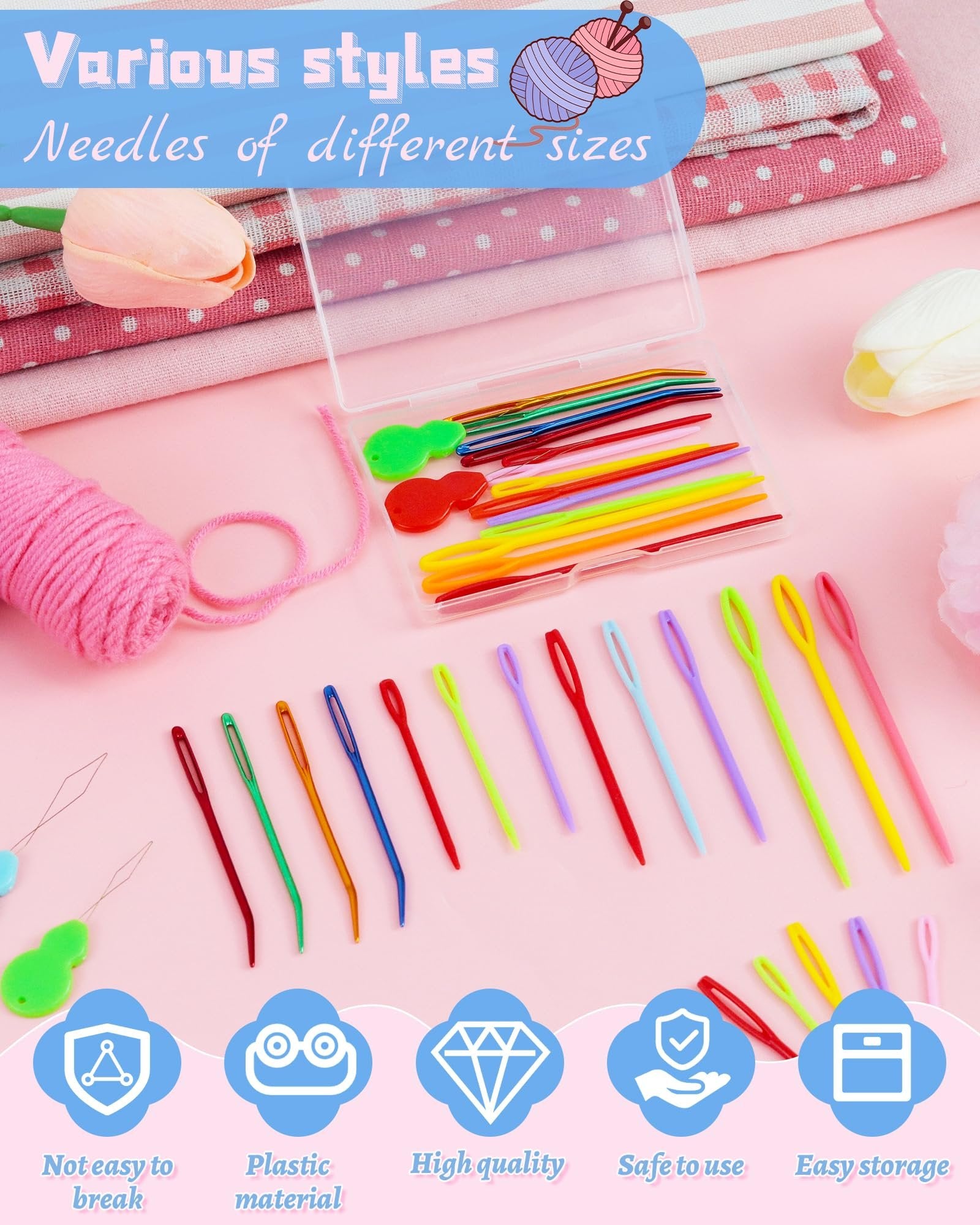 Various styles of yarn needles and threaders laid out with a pink yarn ball and fabric.