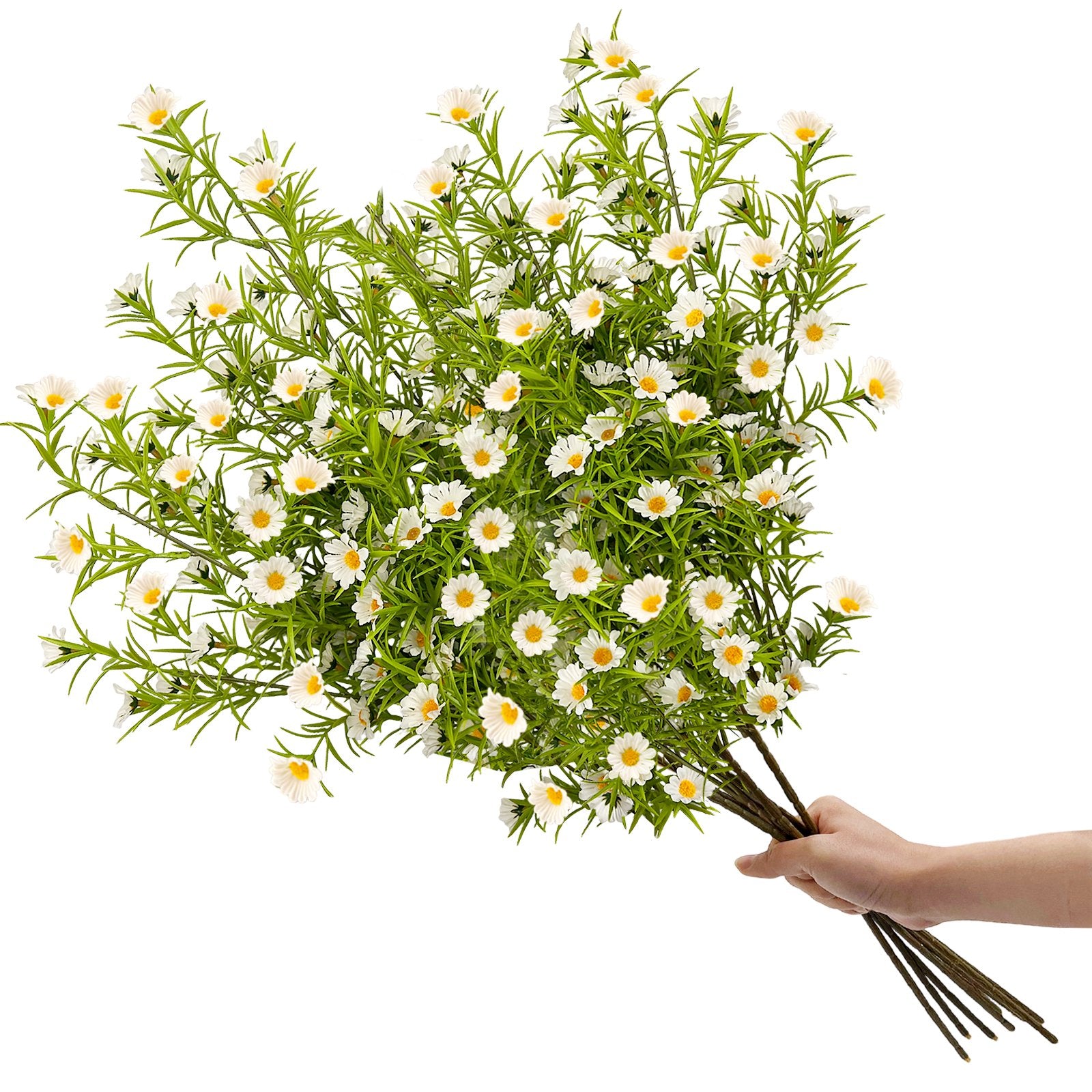 Hand holding a bouquet of artificial white daisy flowers with green stems and leaves against a white background.