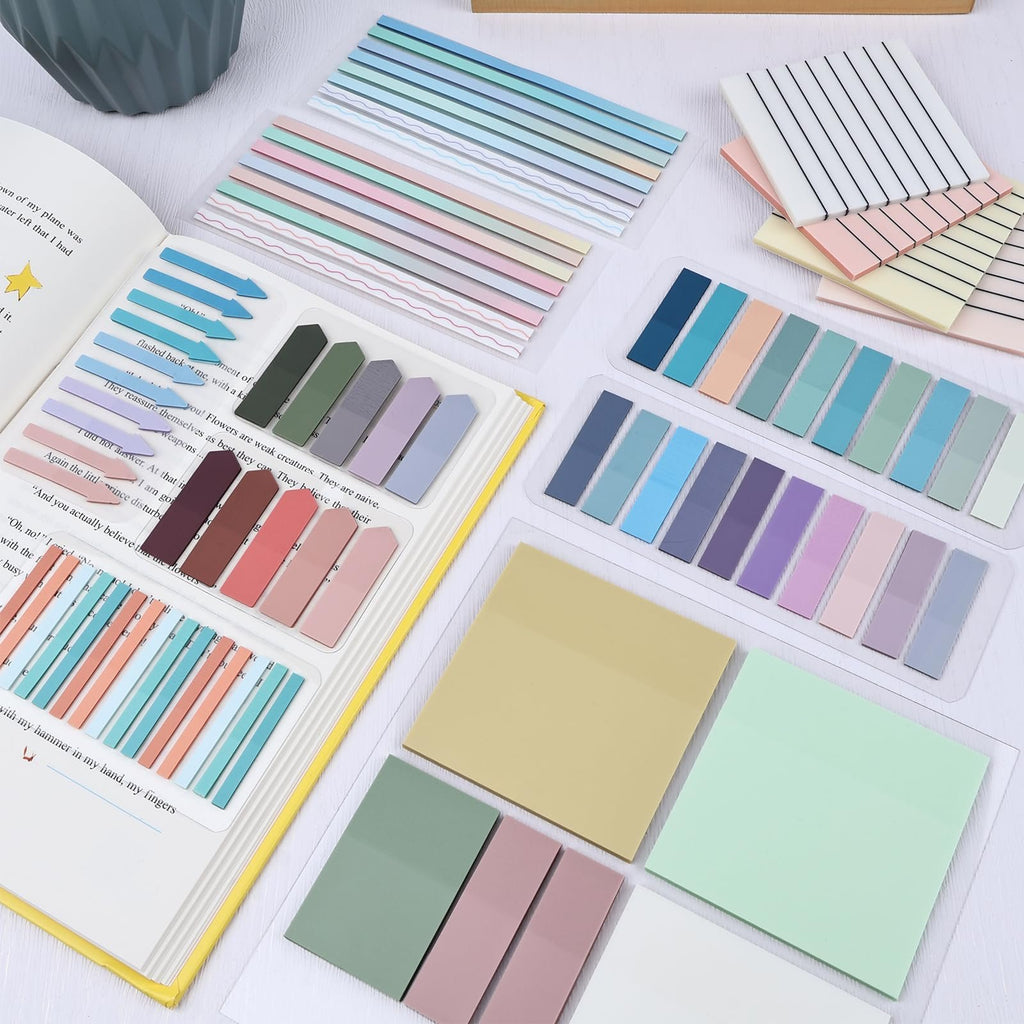 Various transparent sticky notes and page markers in pastel colors arranged on an open book and clear plastic sheets.