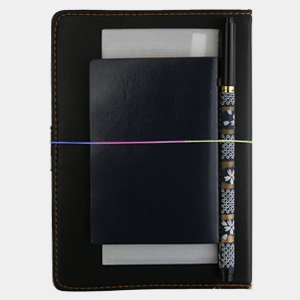 Black faux leather journal with a navy blue insert, a pen, and rainbow elastic cord holding them together.