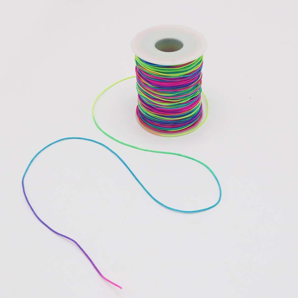 Spool of rainbow elastic beading cord with a length of cord unspooled on a white background.