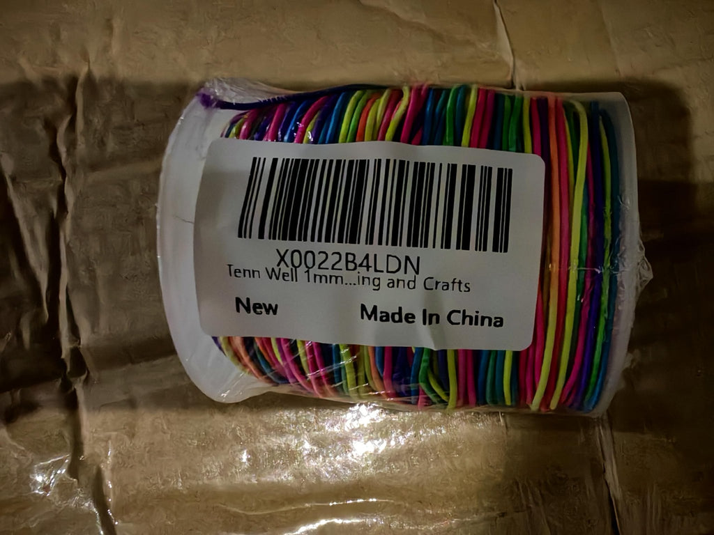 Roll of rainbow elastic beading cord, 1mm thick, packaged in plastic with a label.