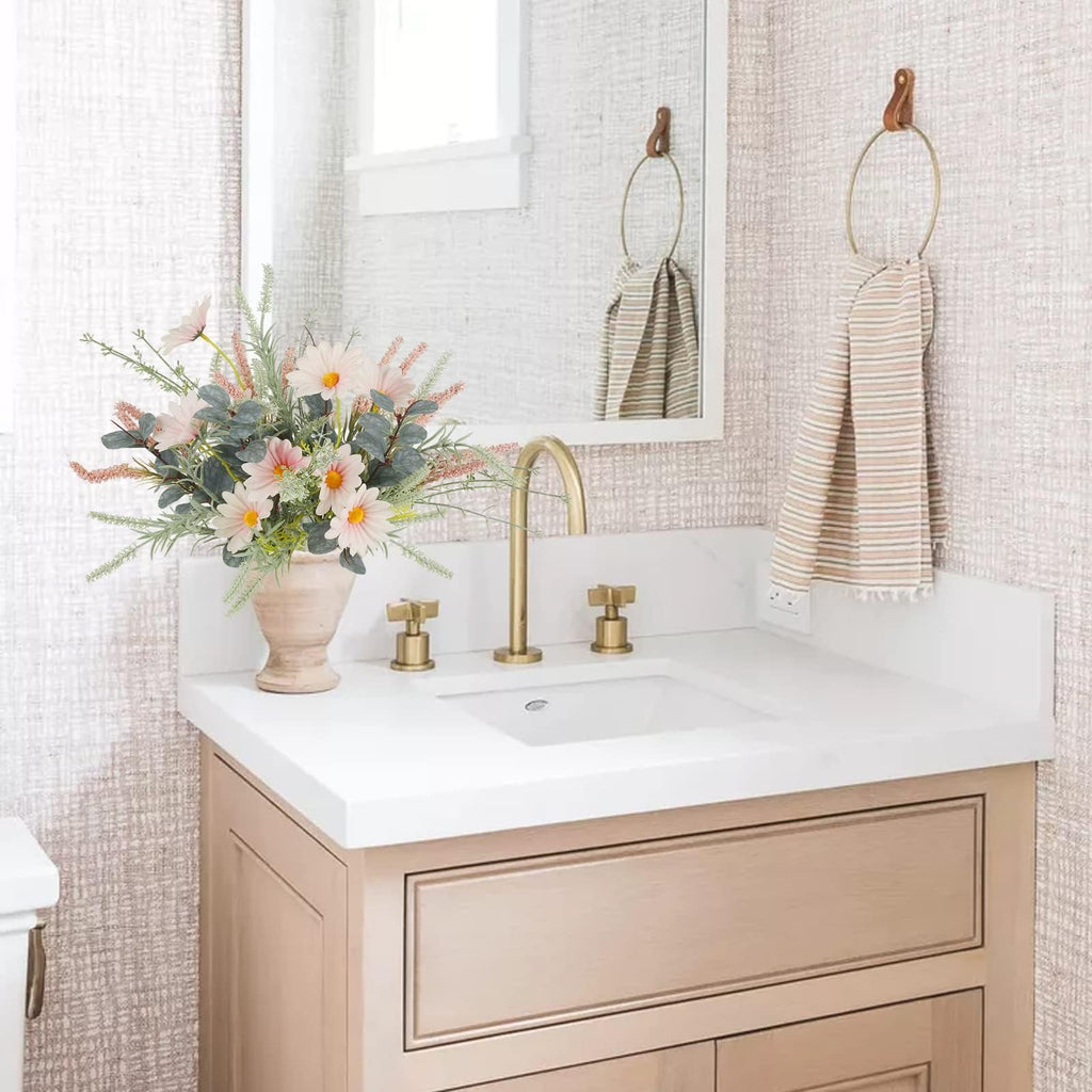 Artificial wildflower bouquet with pink daisies and eucalyptus in a vase on a bathroom vanity
