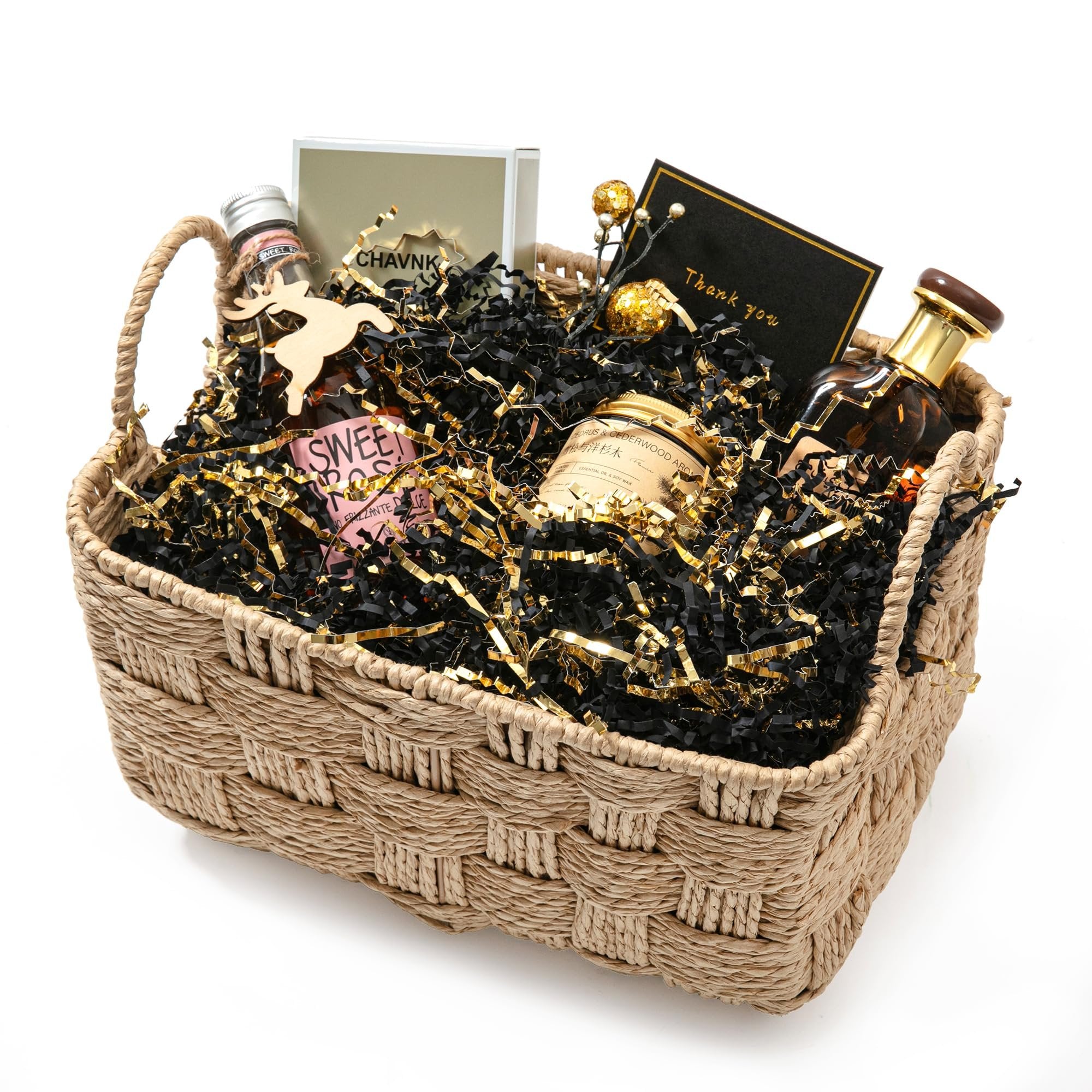 Gift basket filled with black and gold crinkle paper shred, bottles, a candle, and a thank you card.