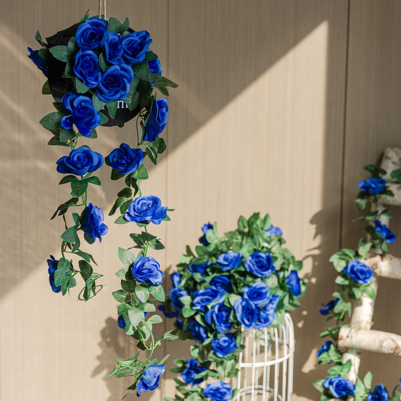 Artificial royal blue rose vine garland with silk flowers and ivy leaves hanging and draped