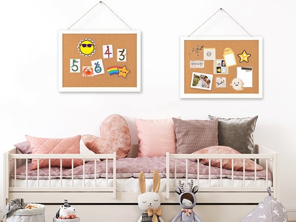 Two cork boards with white frames hanging above a bed, one decorated with numbers and stickers, the other with photos and notes.