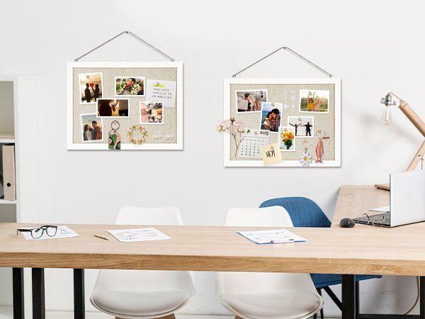 Two white-framed cork boards with photos and decorations hanging on a wall above a wooden desk.