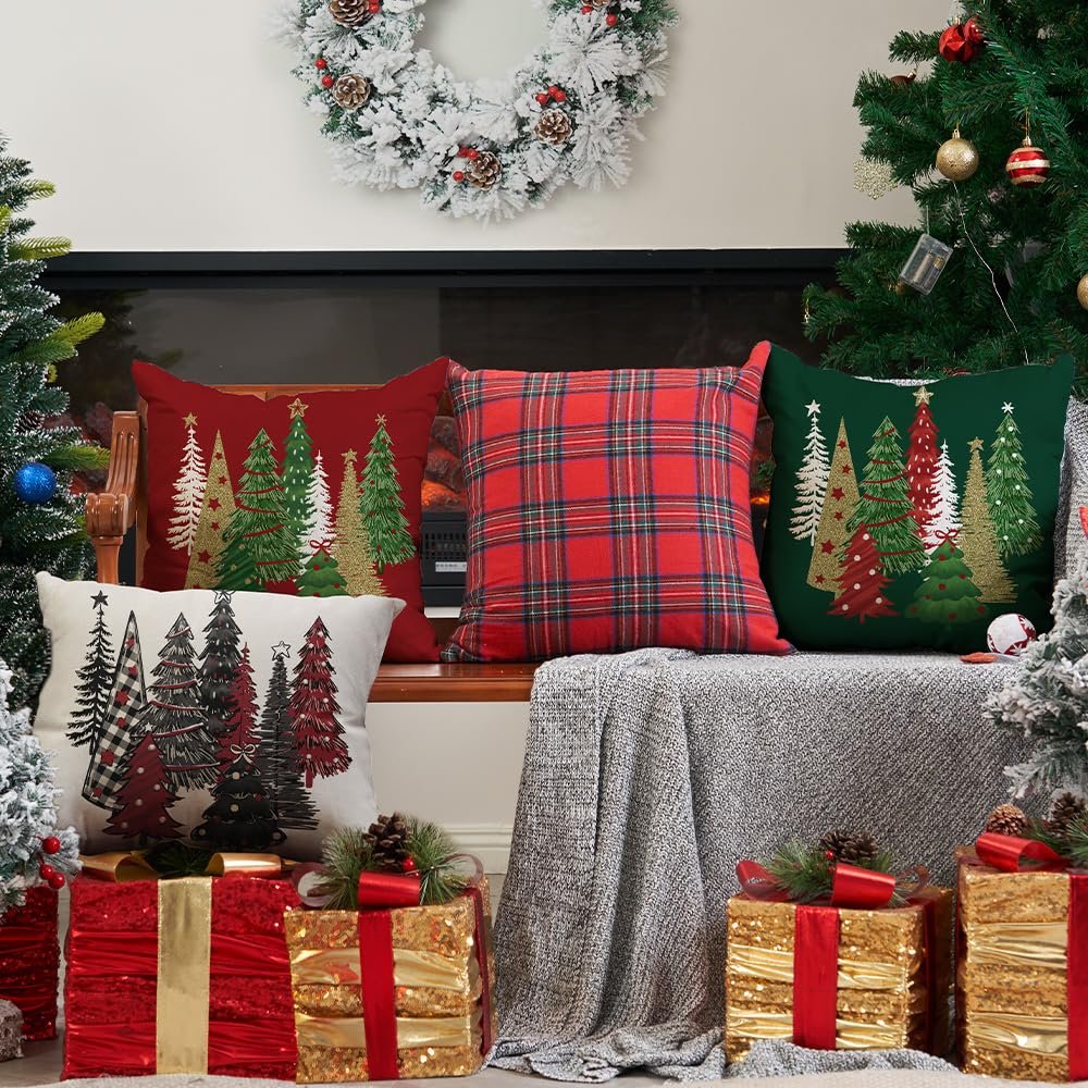 Four Christmas-themed pillow covers arranged on a bench with festive decorations and gifts.