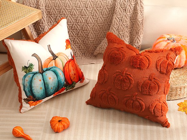 Two decorative throw pillows with fall pumpkin designs, one with watercolor pumpkins and the other with textured pumpkins.