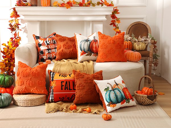 Fall-themed throw pillows with pumpkins and autumn leaves arranged on a couch and ottoman.