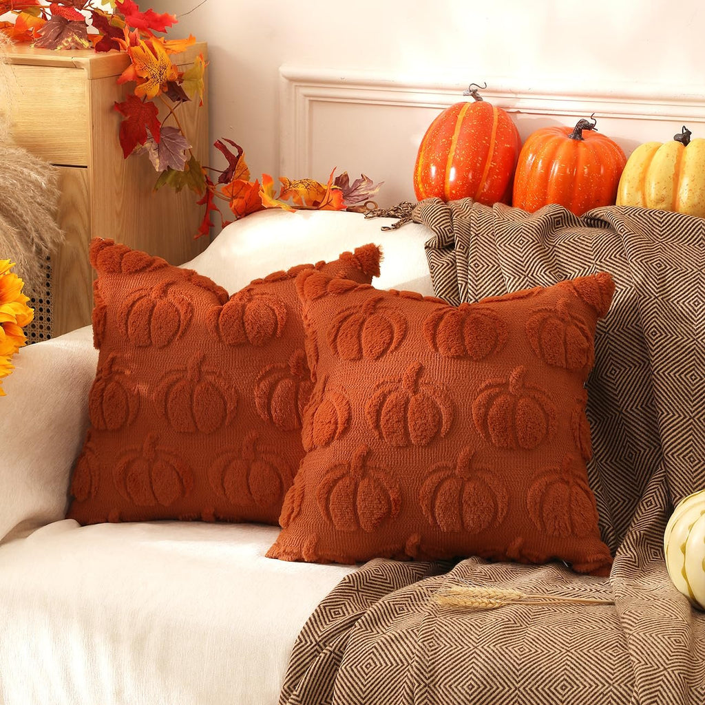 Two rust orange faux fur pumpkin throw pillow covers with textured pumpkin designs are displayed on a couch with fall decor.
