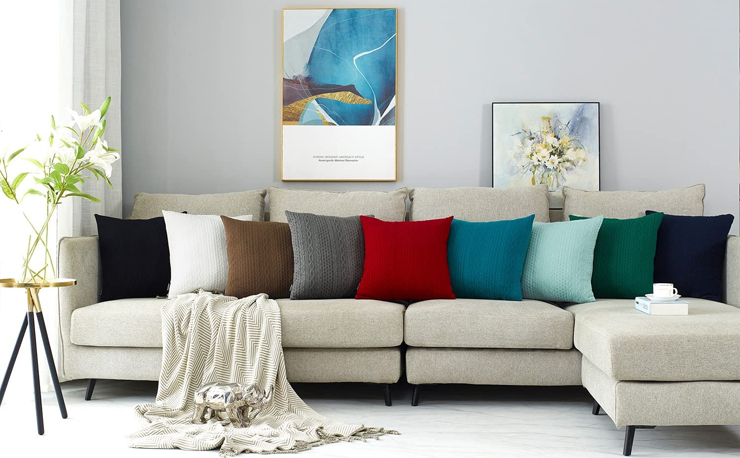 Assortment of knit throw pillow covers in various colors displayed on a sectional sofa with a blanket and decorative items.