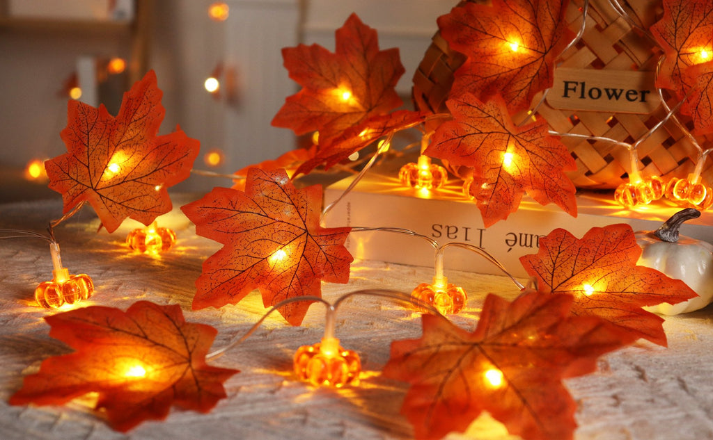 Close-up of battery-operated fall garland with maple leaves and pumpkin lights, illuminated.