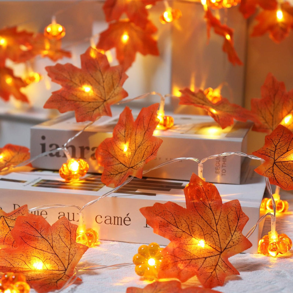 Close-up of battery-operated fall garland with maple leaves and pumpkins, lit with warm white LEDs.