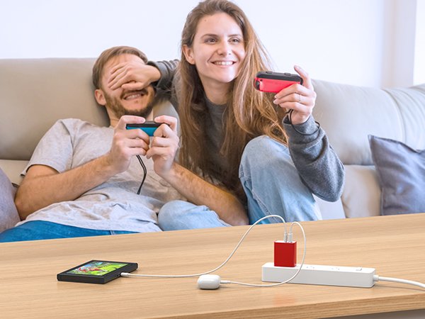 Couple playing video games while a phone and charger are on a table