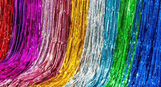 Rainbow metallic fringe curtains cascading down, showing red, pink, gold, silver, teal, green, and blue colors.
