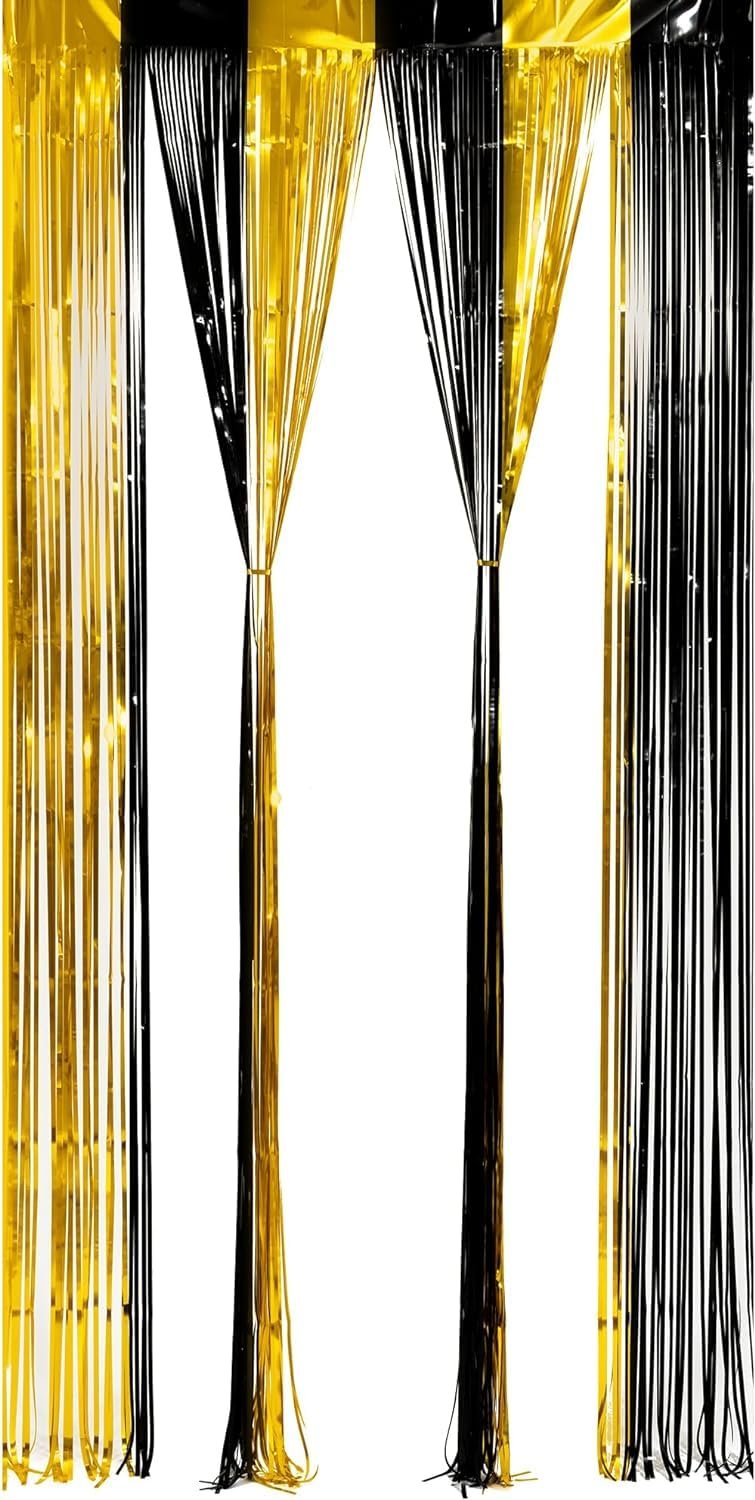 Black and gold foil fringe curtains hanging against a white background, showing the texture and shine of the streamers.
