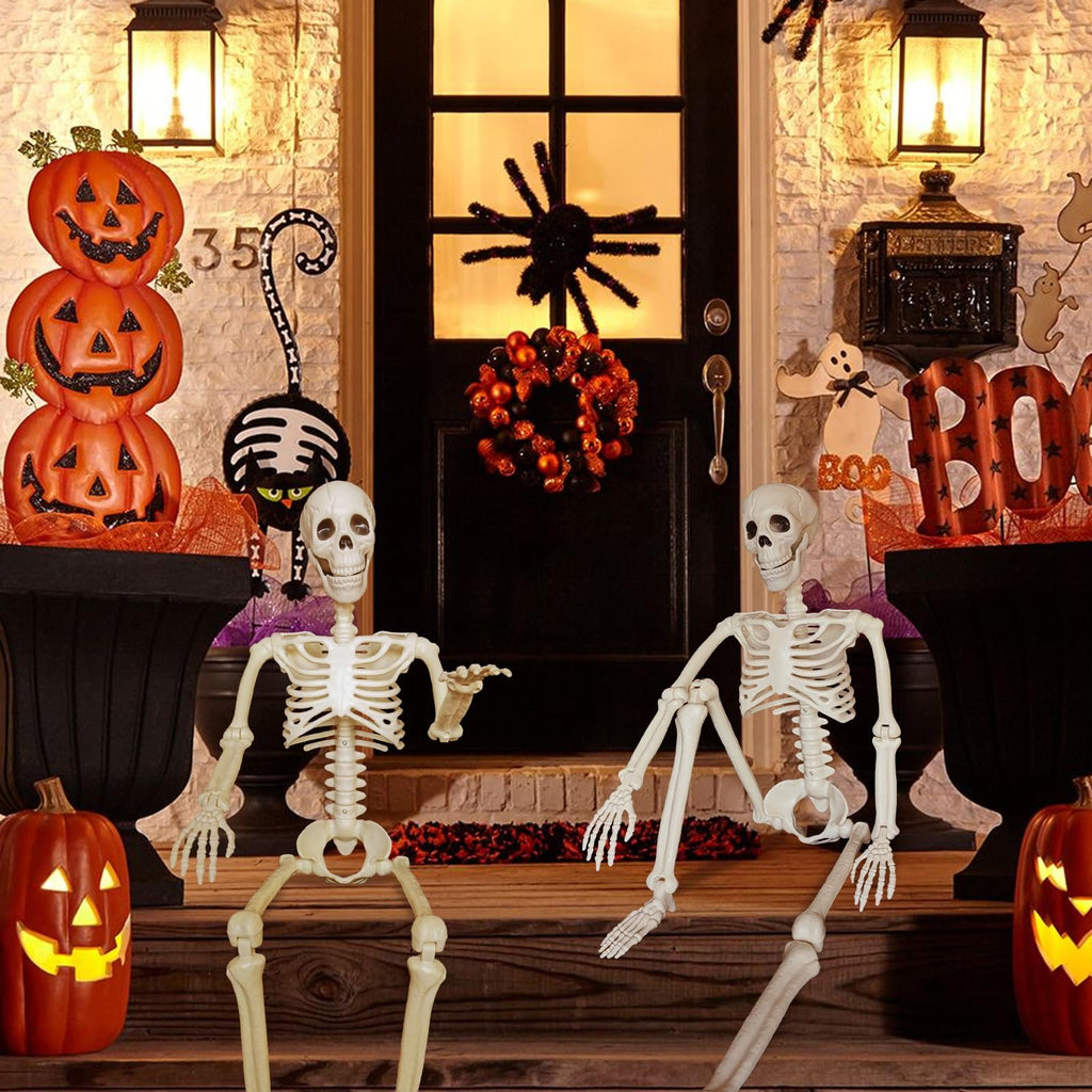 Two posable skeleton Halloween decorations sit on a porch with pumpkins and other spooky decor.